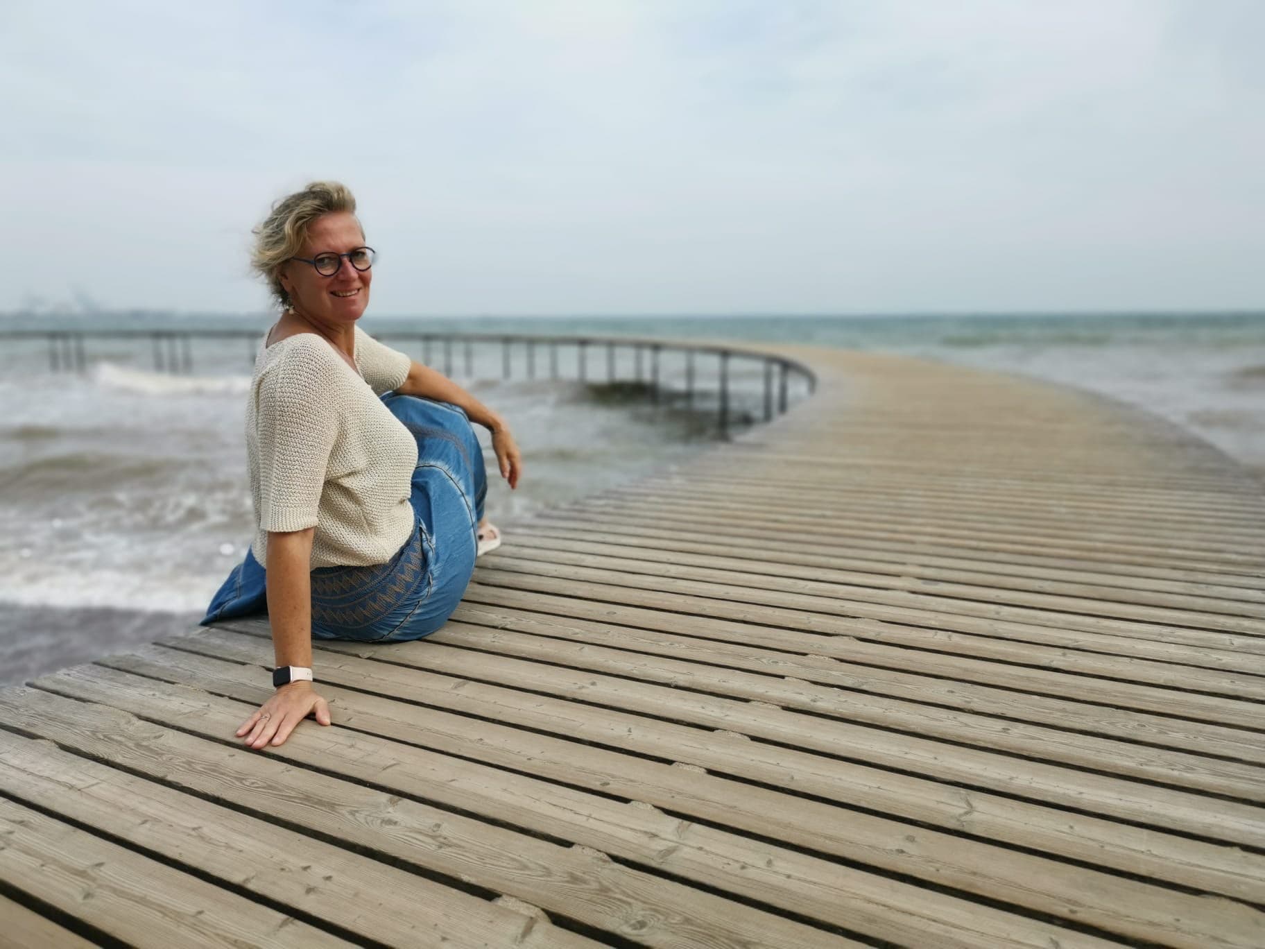 Rien Sanders — coach en energetisch healer op een steiger aan het strand